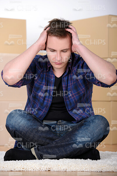 Worried Man Puts Hands on Head White Sits on Carpet Stock Photo