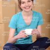 Young Woman Drinking Coffee and Sitting on the Floor Stock Photo