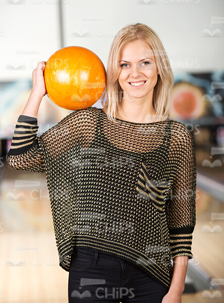 Lady Holds Bowling Ball On Her Shoulder Stock Photo