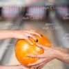 Close Up Hands On Orange Bowling Ball Stock Photo