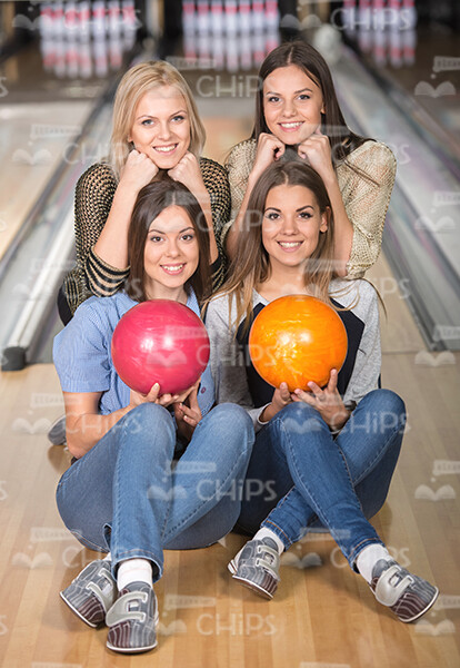 Handsome Ladies Sitting On Bowling Alley Floor Stock Photo