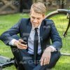 Young Businessman Sitting On Grass And Using His Phone Stock Photo