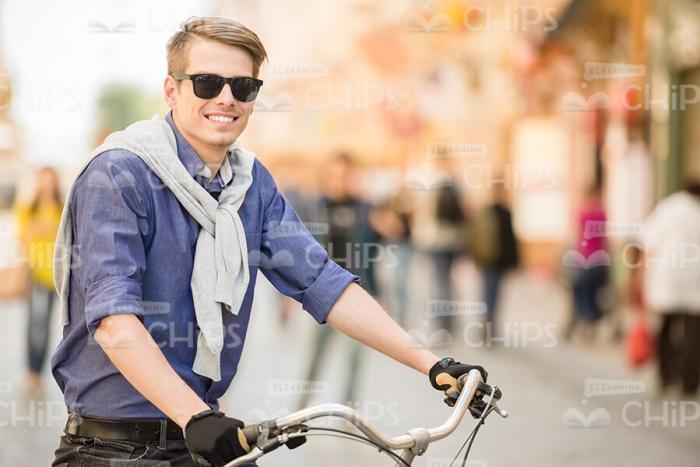 Attractive Young Man Riding Bike Stock Photo