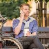 Nice Young Man Sits On Bench And Talks On Mobile Phone Stock Photo