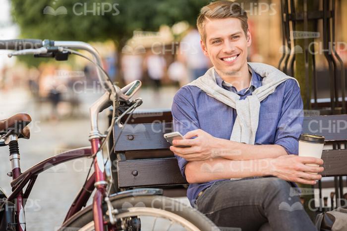 Happy Young Guy Resting On Bench Stock Photo