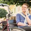Smiling Young Man Talking On Phone And Looking Into The Distance Stock Photo