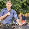 Smiling Man Standing Next To Bicycle Stock Photo
