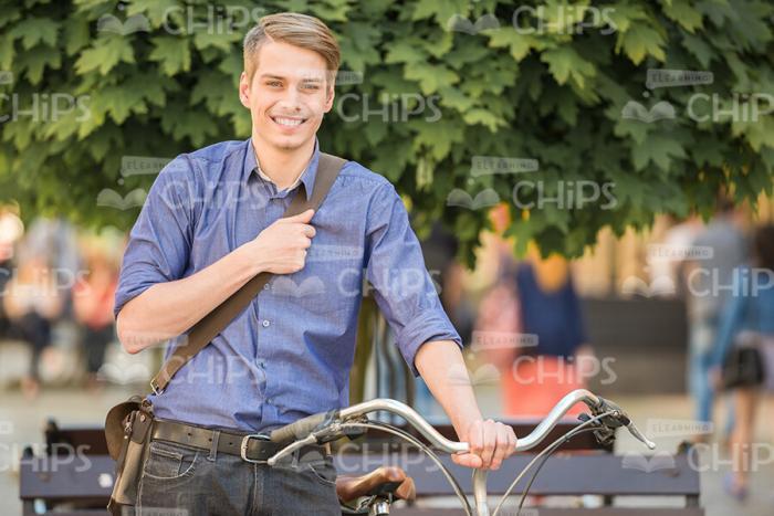 Smiling Man Standing Next To Bicycle Stock Photo
