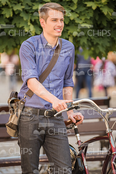 Confident Young Guy With His Bicycle Stock Photo