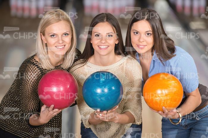 Three Handsome Women Holding Bowling Balls Stock Photo