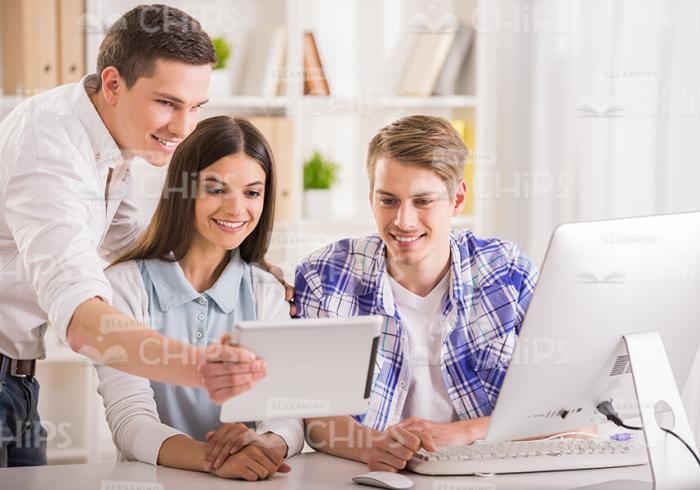 Three Friends Look On Tablet Stock Photo