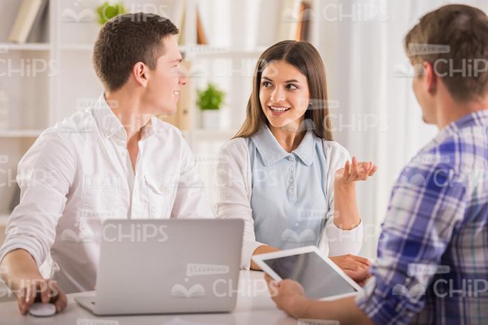 Young Lady Explaining Something To Her Colleagues Stock Photo