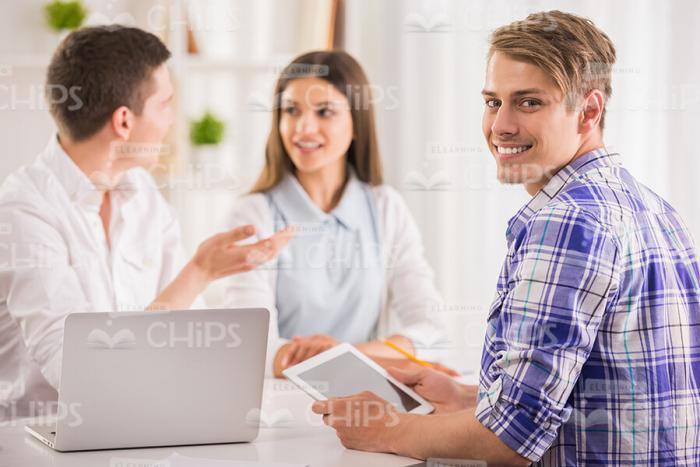Man And Woman Talking To Each Other While Student Holding Tablet Stock Photo
