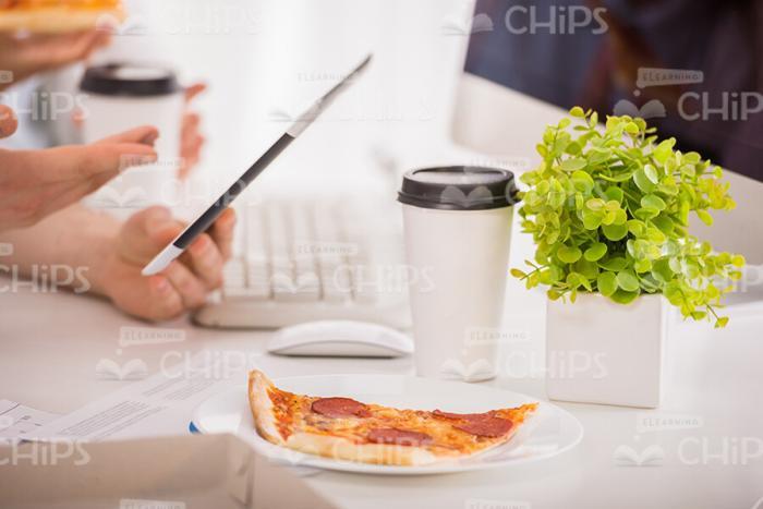 Slice Of Pizza And Coffee Cup On Workplace Stock Photo