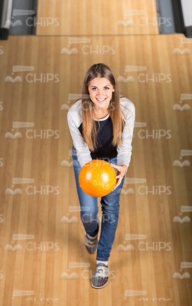 Smiling Girl Holds Bowling Ball With Outstretched Hands Top View Stock Photo