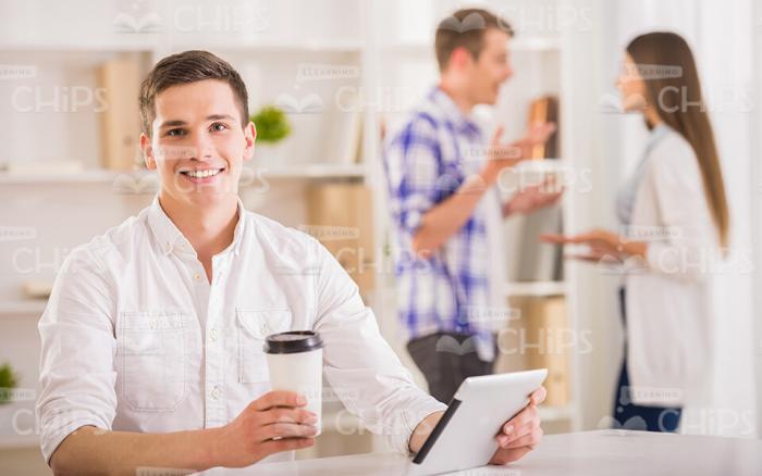 Young Man With Coffee Holding Tablet Stock Photo