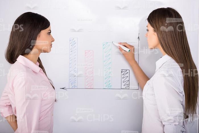 Young Women Draw Graph Stock Photo