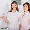 Two Ladies Smile And Show Their Thumbs Up Stock Photo
