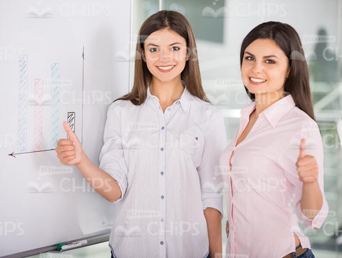 Two Ladies Smile And Show Their Thumbs Up Stock Photo