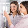 Smiling Ladies Writing On Flipchart Stock Photo