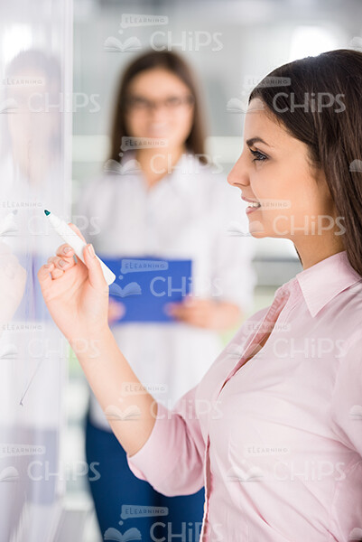 Profile View Of Young Girl Drawing Something On Whiteboard Stock Photo