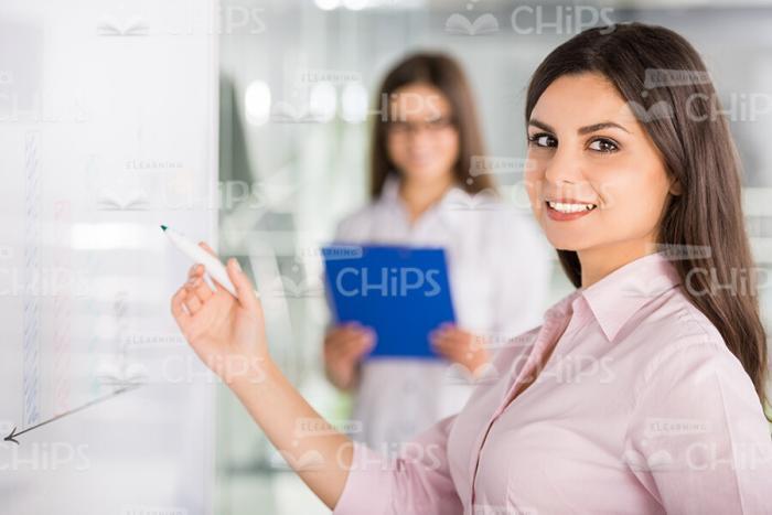 Young Lady Standing Next To Whiteboard And Holding Marker Stock Photo