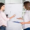 Two Cute Businesswomen Conduct Training Session Stock Photo