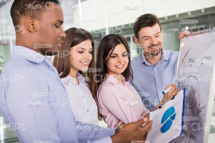 Young Man Showing Diargam To Colleagues Stock Photo