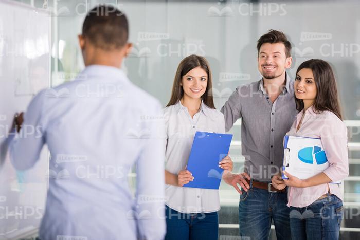 Young Man Explaining Material To His Colleagues Stock Photo