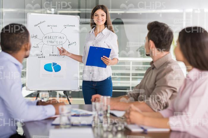 Smiling Woman Pointing On Flipchart Stock Photo