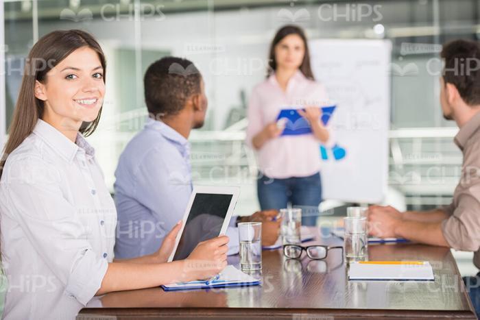 Young Businesswoman Using Tablet While Being On Meeting Stock Photo