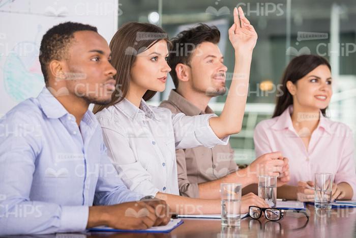 Young Woman Raises Her Hand Up While Wants To Say Few Words Stock Photo