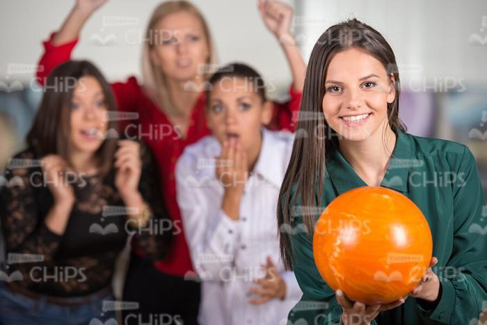 Young Woman With Orange Bowling Ball Smiles Stock Photo