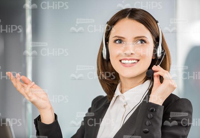 Smiling Lady Wearing Headset And Using It To Talk By Phone Stock Photo