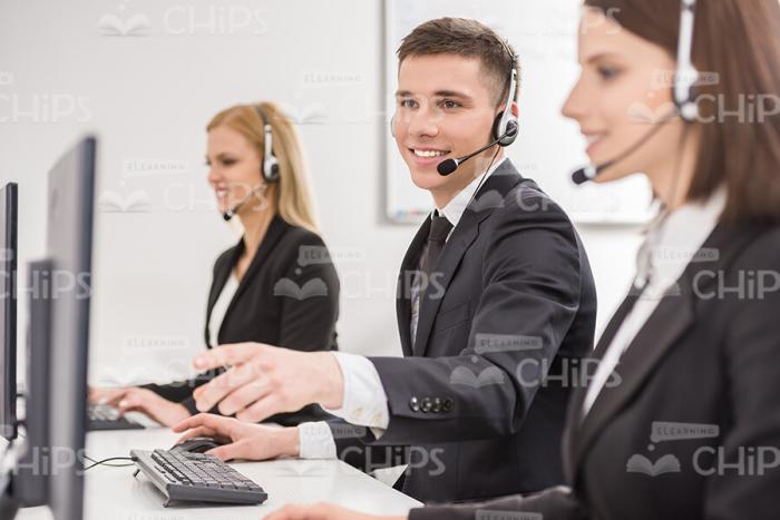 Smiling Man Pointing At Colleagues Display Stock Photo