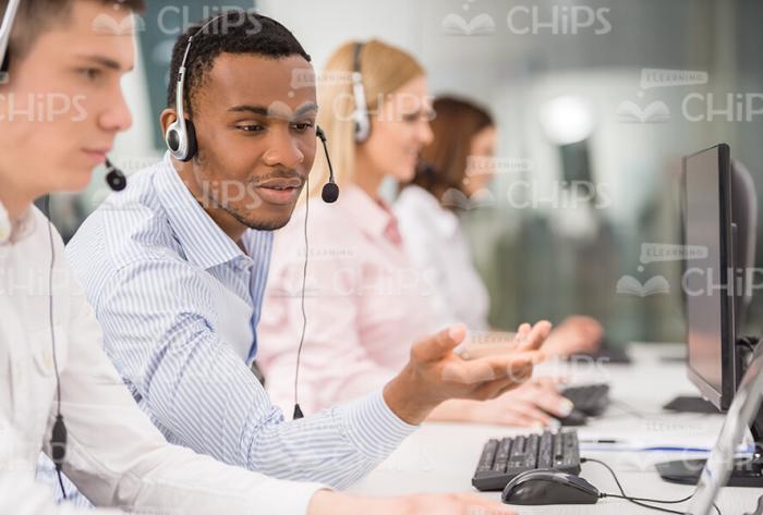 Black Man In Headphones Explaining Something To His Colleague Stock Photo