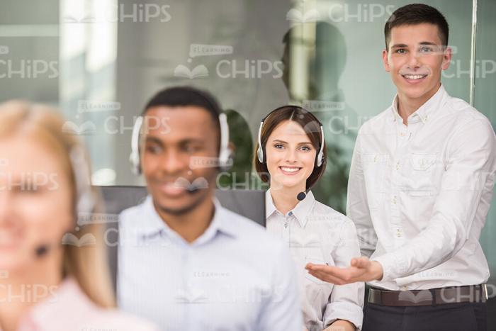 Team Leader Helping Young Worker Stock Photo