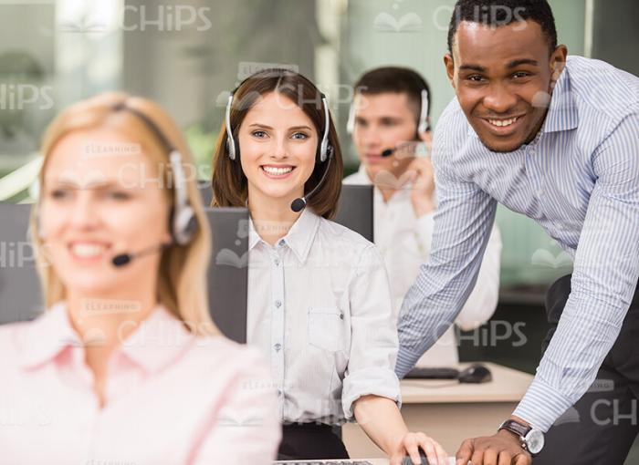 Smiling Young Manager Standing Next To Call Center Operator Stock Photo