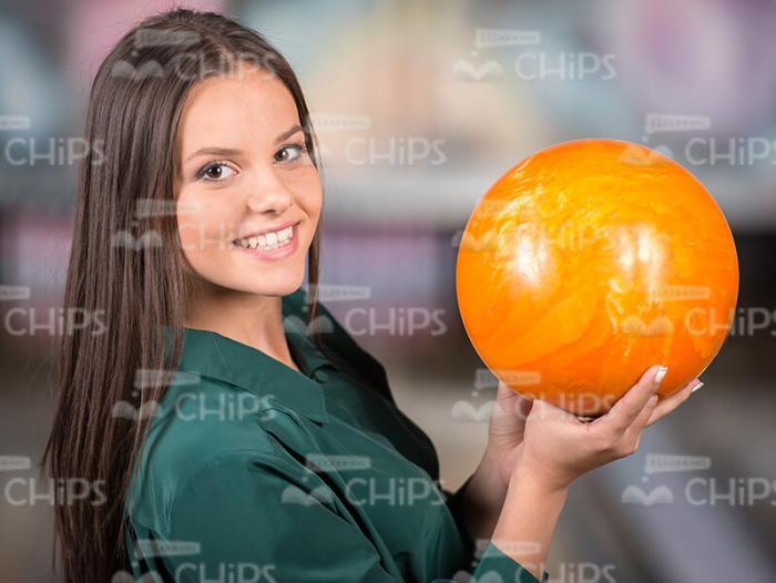 Glad Young Woman Holds Bowling Ball In Right Hand Stock Photo
