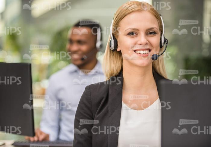 Smiling Lady Talking On Phone While Using Headset Stock Photo