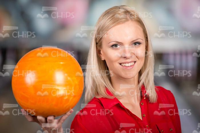 Blonde Woman In Red Blouse Holds Bowling Ball Stock Photo