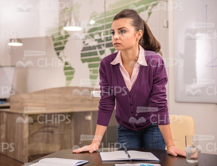 Concentrated Woman Leaning On Table Stock Photo