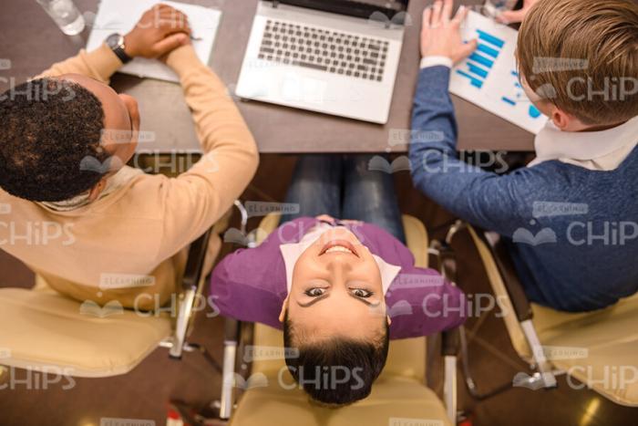 Glad Young Woman Raises Head And Looks At Camera Stock Photo