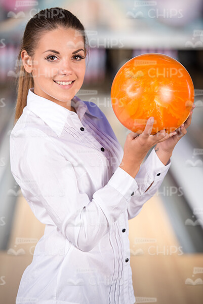 Cute Young Woman Holding Bowling Ball With Both Hands Stock Photo