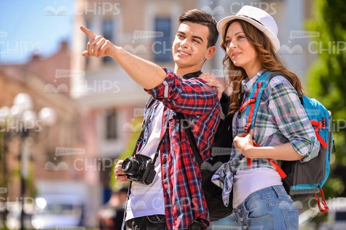 Handsome Man Pointing Forward While Showing Something To His Girlfriend Stock Photo
