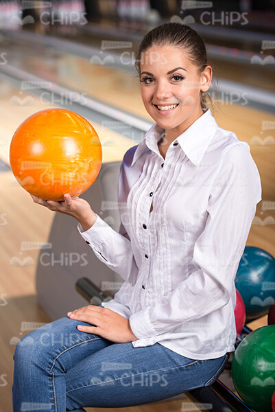 Smiling Girl Holds Orange Bowling Ball Stock Photo