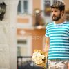 Sad Young Man With Bouquet Waiting For Someone Stock Photo