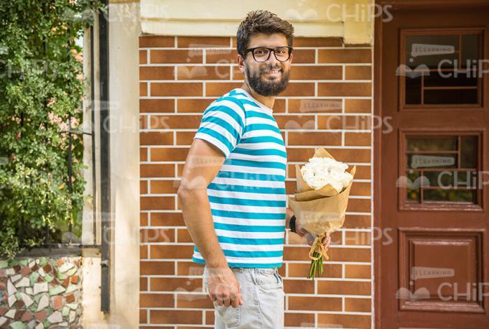 Smiling Bearded Man With Bouquet Turns To Camera Stock Photo