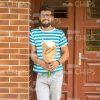 Young Man Standing Next To Door And Holding Bouquet Stock Photo