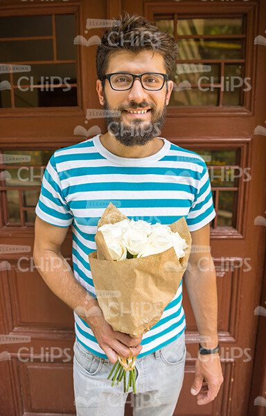 Nice Bearded Man With Bouquet Wearing Stripped T-shirt And Eye Glasses Stock Photo